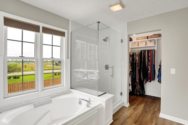 8030 Parcrest Ct, Indianapolis, IN 46259 - full bath featuring a garden tub, a stall shower, a spacious closet, and wood finished floors