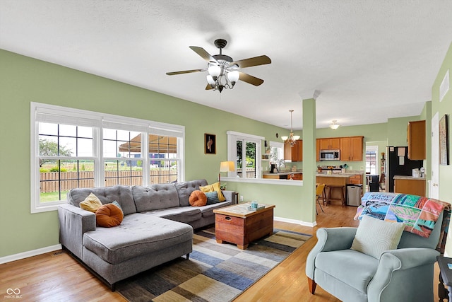 8030 Parcrest Ct, Indianapolis, IN 46259 - living room featuring light wood-type flooring, a ceiling fan, and a chandelier