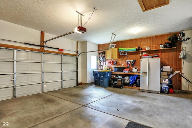 8030 Parcrest Ct, Indianapolis, IN 46259 - garage featuring white fridge with ice dispenser, wooden walls, and a garage door opener