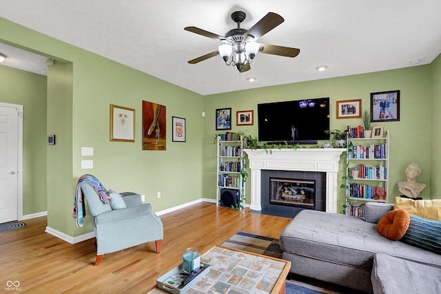 8030 Parcrest Ct, Indianapolis, IN 46259 - living area with wood finished floors, a ceiling fan, and a tiled fireplace