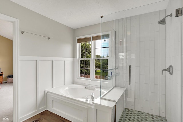 8030 Parcrest Ct, Indianapolis, IN 46259 - full bath featuring a stall shower, a bath, wainscoting, and a textured ceiling
