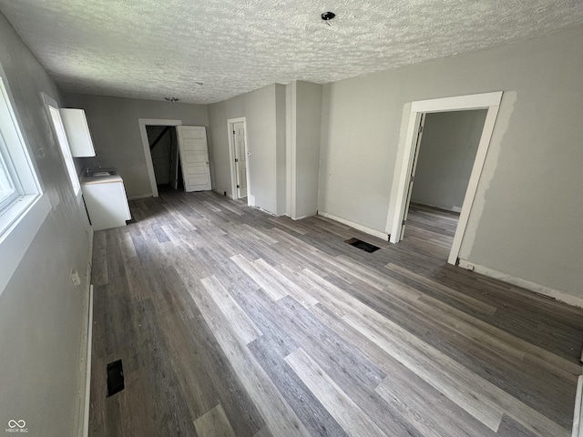 1445 W 34th St, Indianapolis, IN 46208 - unfurnished living room featuring a textured ceiling, wood finished floors, and baseboards