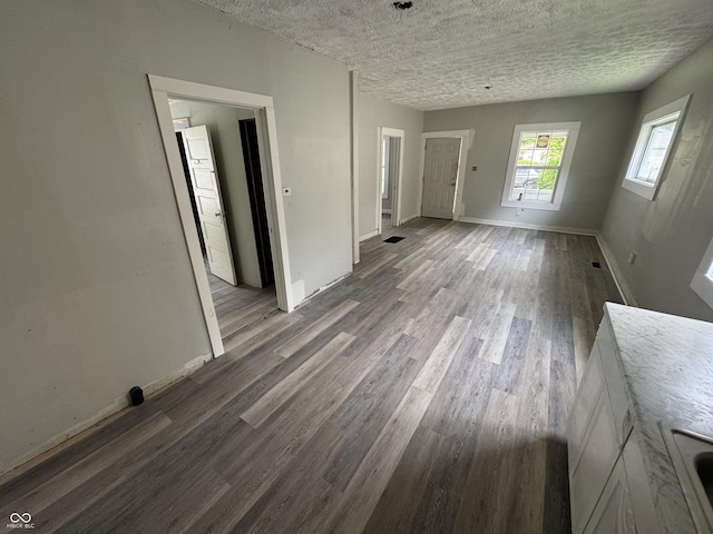 1445 W 34th St, Indianapolis, IN 46208 - unfurnished living room featuring wood finished floors, baseboards, and a textured ceiling