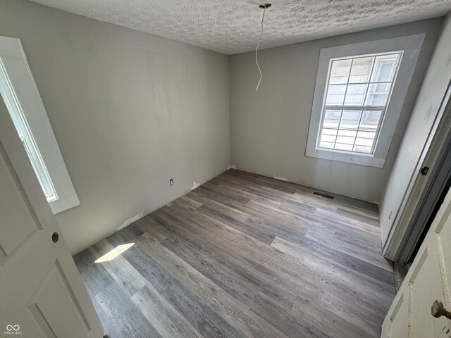 1445 W 34th St, Indianapolis, IN 46208 - unfurnished dining area with wood finished floors and a textured ceiling