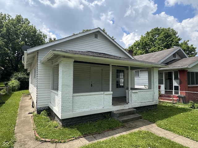 1445 W 34th St, Indianapolis, IN 46208 - view of front facade with brick siding, roof with shingles, and a porch