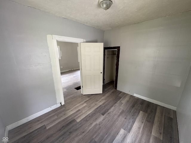 1445 W 34th St, Indianapolis, IN 46208 - unfurnished bedroom with wood finished floors, a textured ceiling, baseboards, and a closet