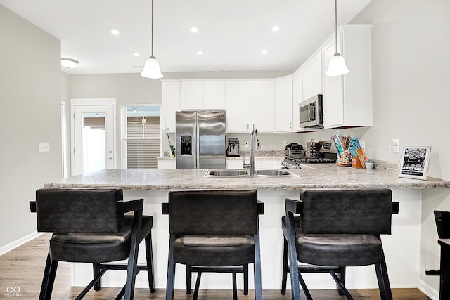 3428 Thomas Jefferson St, Westfield, IN 46074 - kitchen with stainless steel appliances, a sink, a peninsula, decorative light fixtures, and recessed lighting