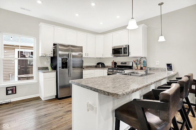 3428 Thomas Jefferson St, Westfield, IN 46074 - kitchen featuring appliances with stainless steel finishes, a sink, a peninsula, recessed lighting, and light wood-style flooring