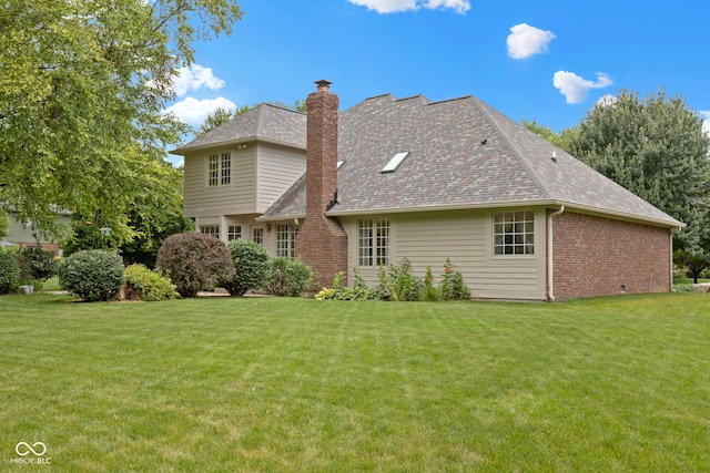 9175 Lakewind Dr, Indianapolis, IN 46256 - back of house featuring brick siding, a chimney, a yard, and roof with shingles
