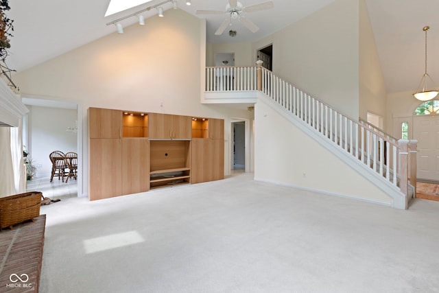 9175 Lakewind Dr, Indianapolis, IN 46256 - unfurnished living room featuring high vaulted ceiling, light carpet, stairway, track lighting, and ceiling fan