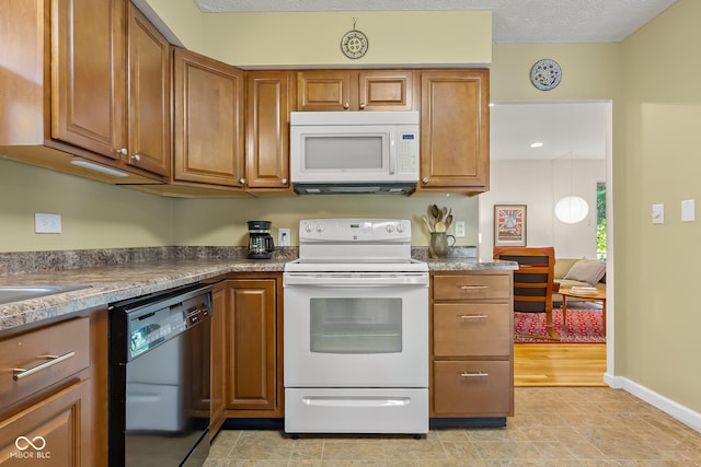2233 Washington St, Columbus, IN 47201 - kitchen with white appliances, brown cabinetry, and baseboards