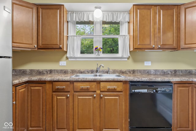 2233 Washington St, Columbus, IN 47201 - kitchen featuring black dishwasher, a sink, brown cabinetry, and freestanding refrigerator