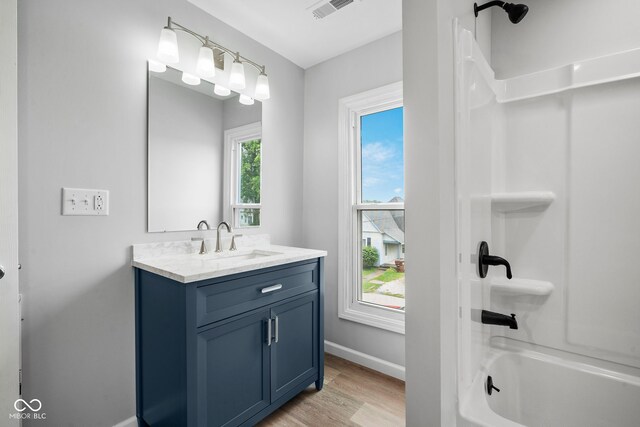 110 E Mcdonald St, Brazil, IN 47834 - bathroom with vanity, baseboards, wood finished floors, and tub / shower combination