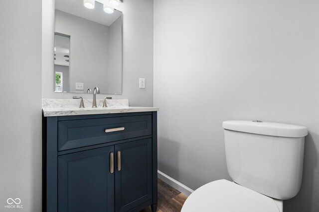 110 E Mcdonald St, Brazil, IN 47834 - half bathroom with wood finished floors, toilet, vanity, and baseboards