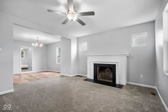 110 E Mcdonald St, Brazil, IN 47834 - unfurnished living room with carpet, ceiling fan, a brick fireplace, a chandelier, and baseboards