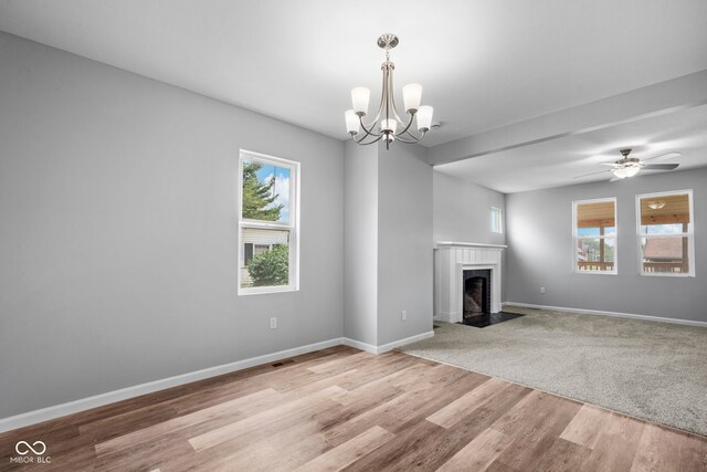110 E Mcdonald St, Brazil, IN 47834 - unfurnished living room featuring a chandelier, wood finished floors, a fireplace with flush hearth, and baseboards