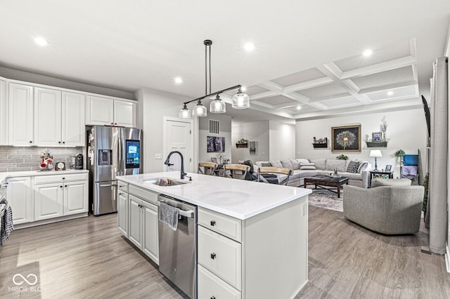1107 Mccray Ln, Westfield, IN 46074 - kitchen with stainless steel appliances, a sink, light wood finished floors, light countertops, and a center island with sink