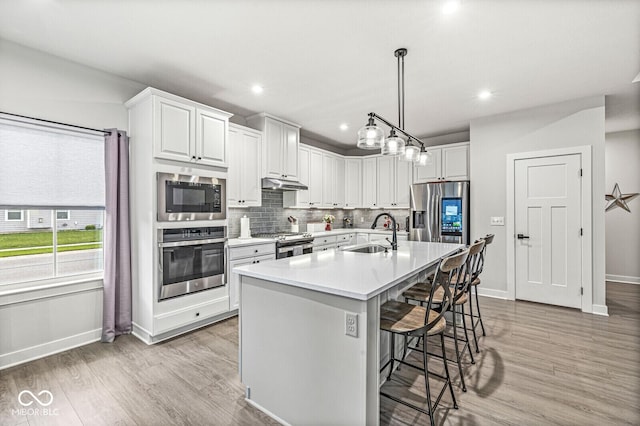 1107 Mccray Ln, Westfield, IN 46074 - kitchen featuring stainless steel appliances, a sink, baseboards, a breakfast bar area, and tasteful backsplash