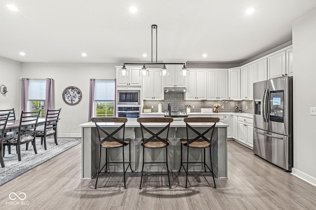 1107 Mccray Ln, Westfield, IN 46074 - kitchen featuring appliances with stainless steel finishes, white cabinetry, light wood finished floors, a center island with sink, and recessed lighting