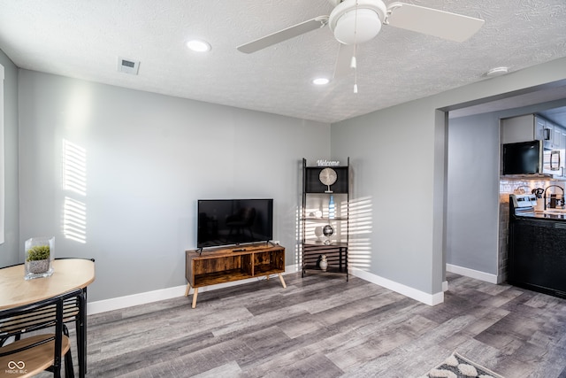 1631 Columbia Ave, Indianapolis, IN 46202 - living area featuring light wood finished floors, a textured ceiling, ceiling fan, recessed lighting, and baseboards
