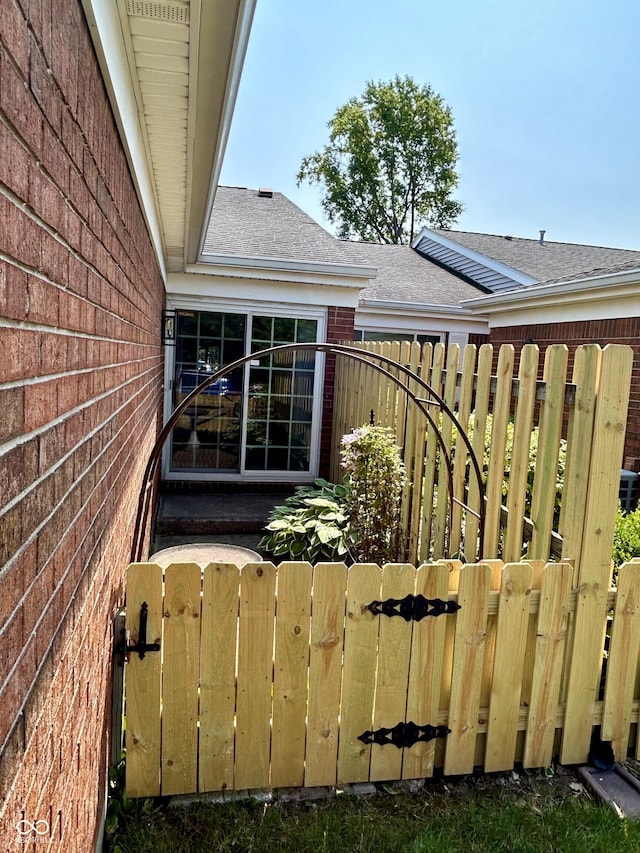 5491 Vin Rose Ln, Lawrence, IN 46226 - view of side of property with roof with shingles, brick siding, and a gate