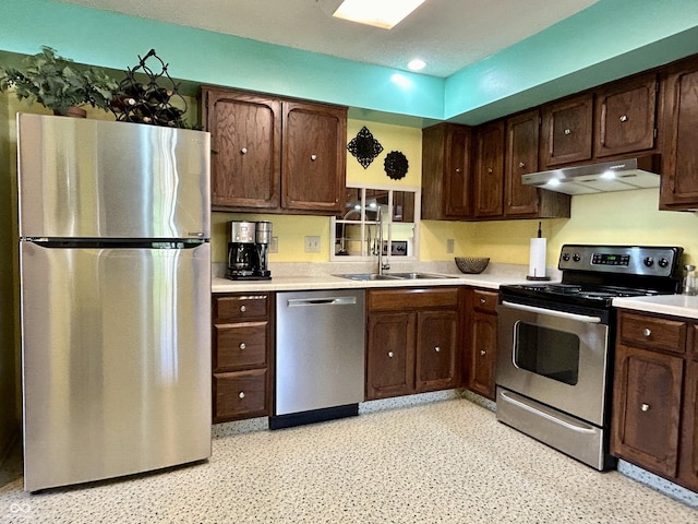 5491 Vin Rose Ln, Lawrence, IN 46226 - kitchen with stainless steel appliances, under cabinet range hood, light countertops, dark brown cabinets, and a sink