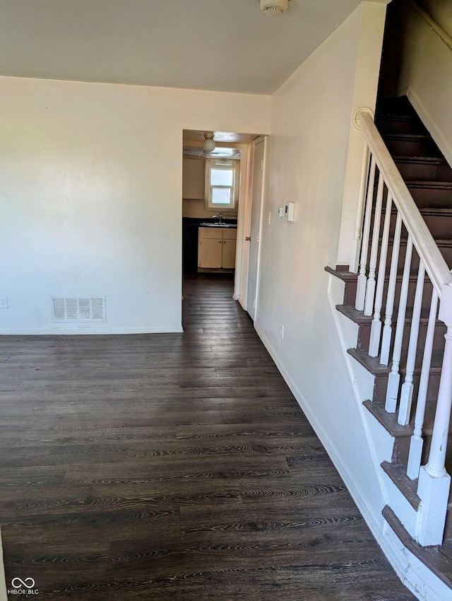 6322 Commons Dr, Indianapolis, IN 46254 - spare room with dark wood-type flooring, a sink, baseboards, and stairway