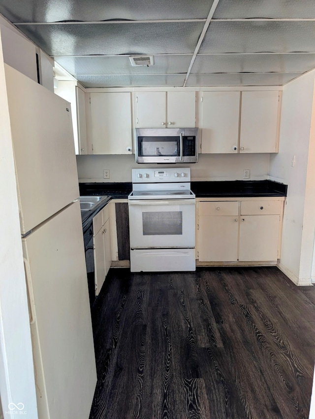 6322 Commons Dr, Indianapolis, IN 46254 - kitchen featuring white appliances, dark wood-type flooring, dark countertops, and a sink