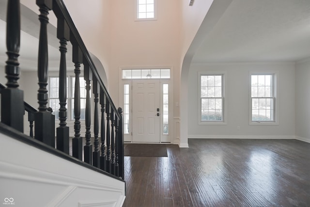 15201 Slateford Rd, Noblesville, IN 46062 - foyer featuring arched walkways, dark wood finished floors, stairway, baseboards, and ornamental molding