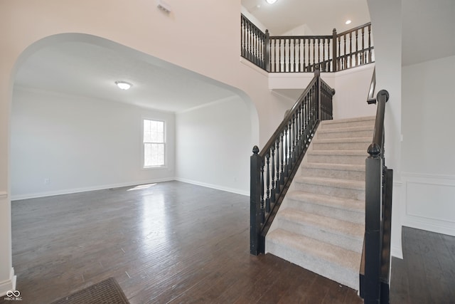15201 Slateford Rd, Noblesville, IN 46062 - staircase with arched walkways, wood finished floors, baseboards, and a high ceiling