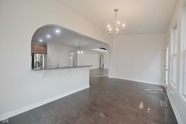 15201 Slateford Rd, Noblesville, IN 46062 - unfurnished living room featuring arched walkways, a chandelier, dark wood-style floors, baseboards, and recessed lighting