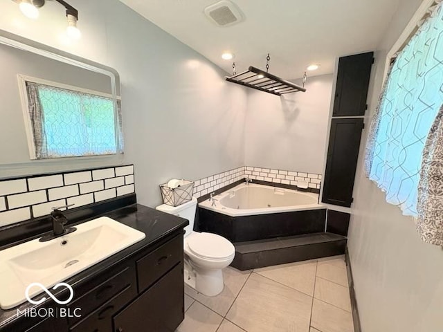 8990 N 850 W, Fairland, IN 46126 - bathroom with toilet, a tub with jets, vanity, tile patterned flooring, and decorative backsplash