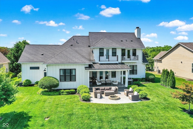 6882 Bladstone Rd, Noblesville, IN 46062 - back of house with an outdoor living space with a fire pit, board and batten siding, a patio, a chimney, and a lawn