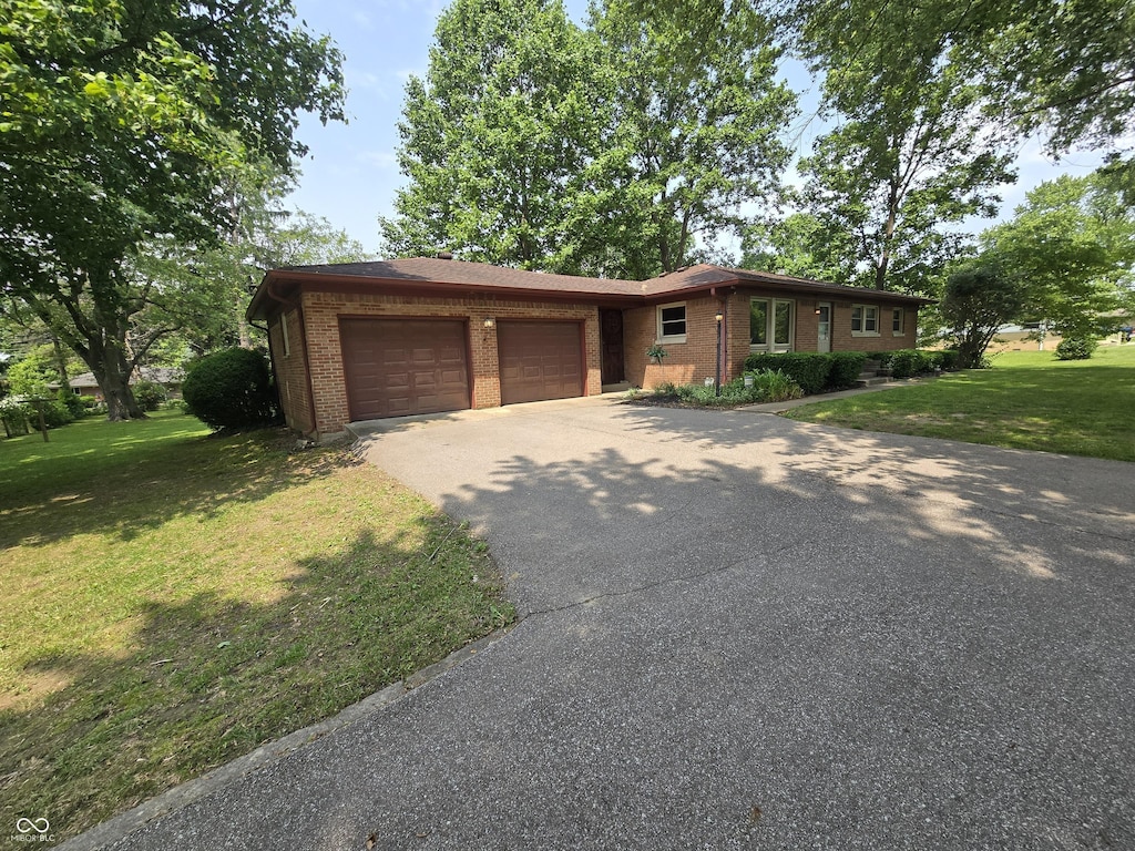 7088 Sandalwood Dr, Indianapolis, IN 46217 - single story home featuring driveway, an attached garage, a front yard, and brick siding