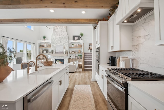 19652 Shadow Trace Path, Westfield, IN 46074 - kitchen featuring stainless steel appliances, custom exhaust hood, a sink, open floor plan, and beam ceiling