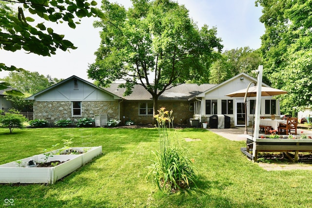 7242 Highburry Dr, Indianapolis, IN 46256 - rear view of property with stone siding, a garden, a lawn, and board and batten siding
