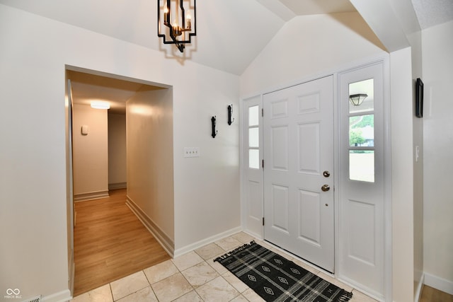 7242 Highburry Dr, Indianapolis, IN 46256 - foyer featuring a chandelier, vaulted ceiling, and light tile patterned floors