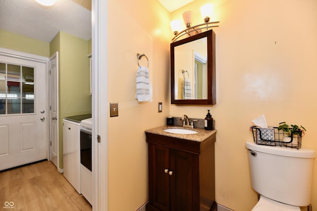 7242 Highburry Dr, Indianapolis, IN 46256 - bathroom with washing machine and dryer, wood finished floors, vanity, and a textured ceiling
