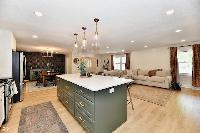 7242 Highburry Dr, Indianapolis, IN 46256 - kitchen with recessed lighting, a center island, appliances with stainless steel finishes, light wood-style flooring, and light countertops