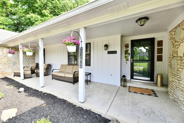 7242 Highburry Dr, Indianapolis, IN 46256 - property entrance with a porch, board and batten siding, an outdoor hangout area, and stone siding