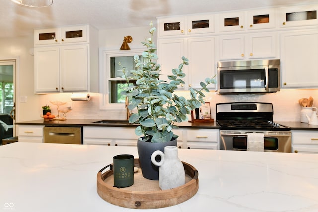 7242 Highburry Dr, Indianapolis, IN 46256 - kitchen with appliances with stainless steel finishes, white cabinets, tasteful backsplash, and dark stone counters