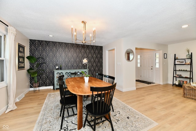 7242 Highburry Dr, Indianapolis, IN 46256 - dining area with an accent wall, a chandelier, light wood-style flooring, recessed lighting, and a textured ceiling