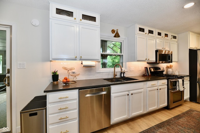 7242 Highburry Dr, Indianapolis, IN 46256 - kitchen featuring appliances with stainless steel finishes, dark countertops, white cabinets, decorative backsplash, and a textured ceiling