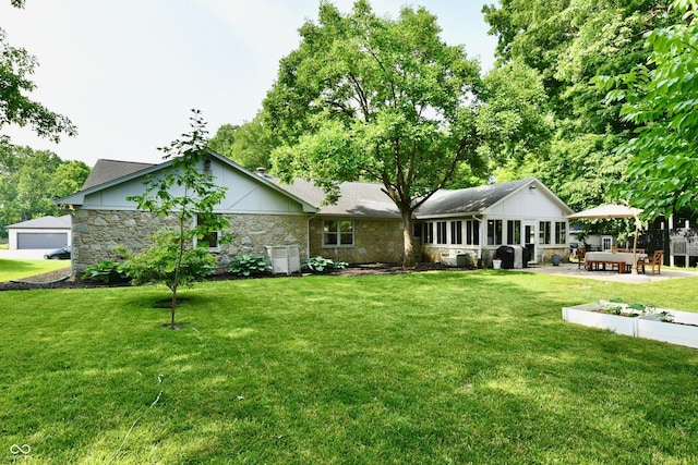 7242 Highburry Dr, Indianapolis, IN 46256 - rear view of house featuring a yard, stone siding, and a patio area