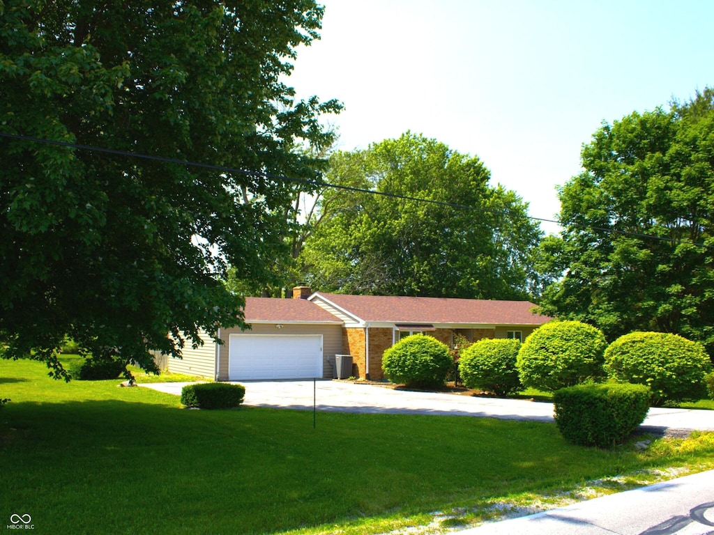 11343 E 191st St, Noblesville, IN 46060 - view of front of house with an attached garage, a front lawn, concrete driveway, and a chimney