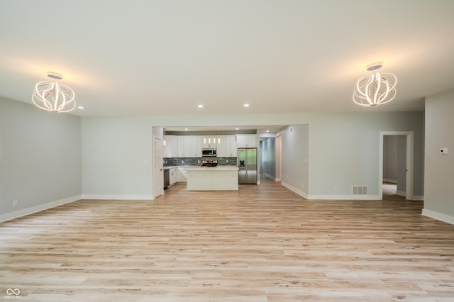 2159 W 58th St NW, Indianapolis, IN 46228 - unfurnished living room with a chandelier, light wood-style flooring, and recessed lighting
