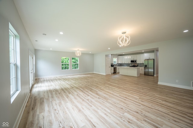 2159 W 58th St NW, Indianapolis, IN 46228 - unfurnished living room with a chandelier, light wood finished floors, and recessed lighting