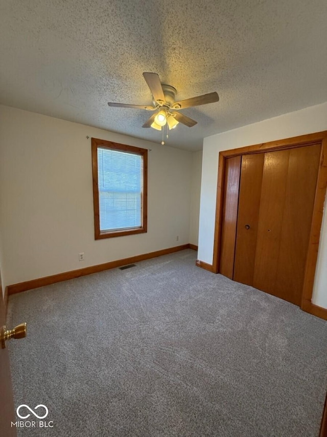 1421 S Meridian St, Indianapolis, IN 46225 - unfurnished bedroom with carpet, a textured ceiling, baseboards, and a closet