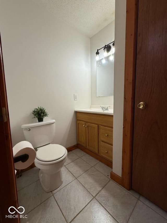 1421 S Meridian St, Indianapolis, IN 46225 - bathroom featuring a textured ceiling, toilet, vanity, tile patterned flooring, and baseboards
