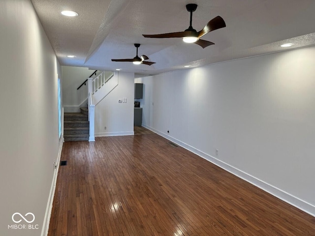 1421 S Meridian St, Indianapolis, IN 46225 - unfurnished living room with dark wood-style flooring, baseboards, stairway, a ceiling fan, and a textured ceiling